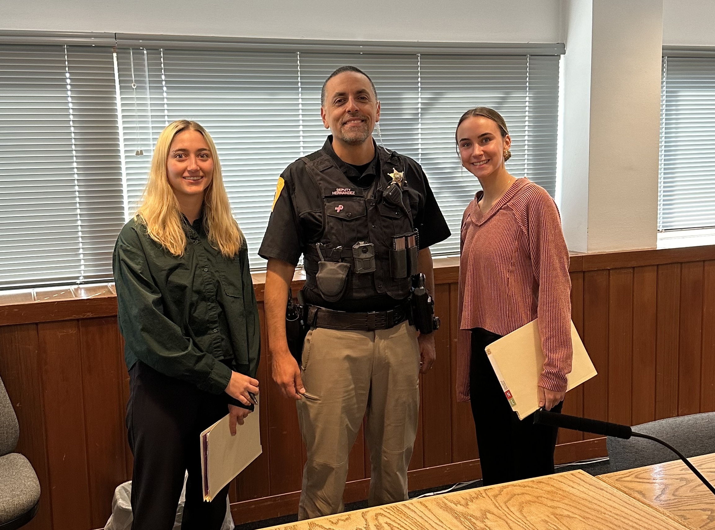 Two students standing next to sheriff's deputy